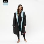 Woman wearing a black and light blue coat on a white background